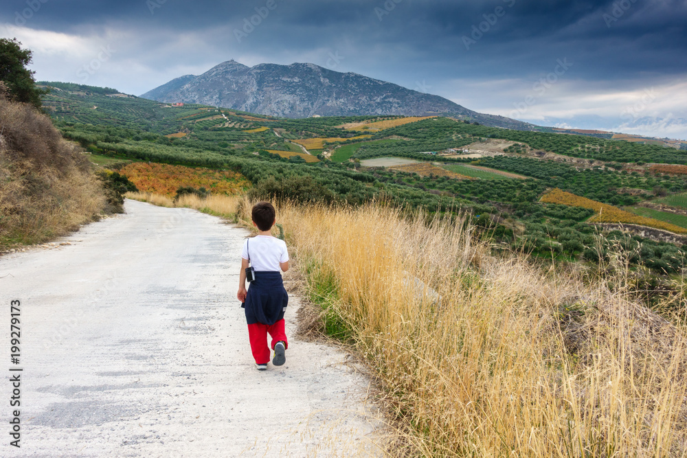 Boy walking alongside farm, Greece