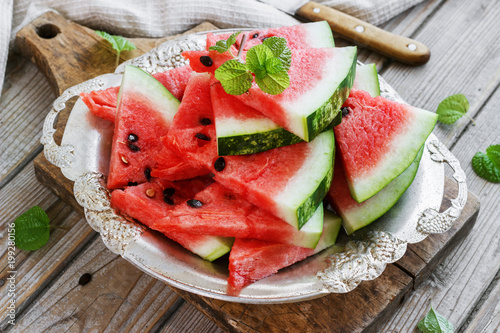 Fresh sliced watermelon in a metal bowl wooden background