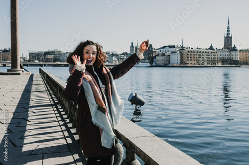 Photography Beautiful young woman taking some pictures from her travel to Stockholm in Sweden from a beautiful view from the old city