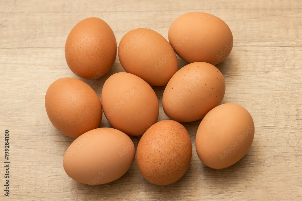 many raw chicken eggs on a wooden background
many raw chicken eggs on a wooden background