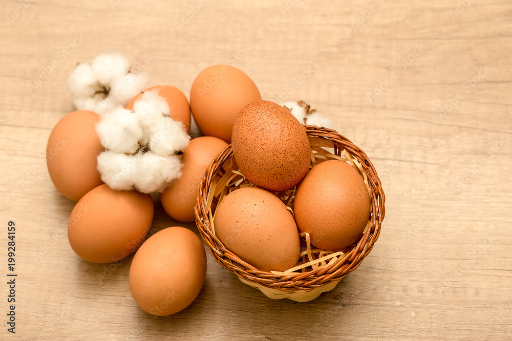 raw chicken eggs and cotton inflorescences on a wooden background
raw chicken eggs and cotton inflorescences on a wooden background