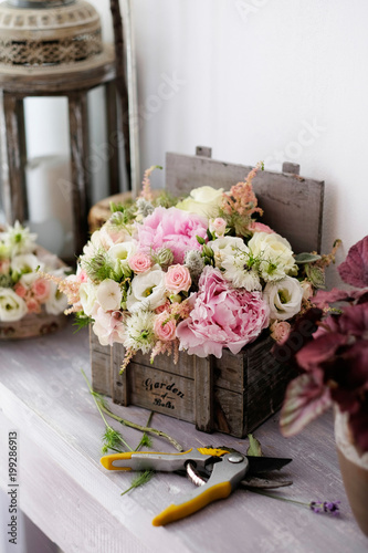 Roses bouquet for wedding. White and pink roses bouquet in a wooden vintage box inside florist shop.