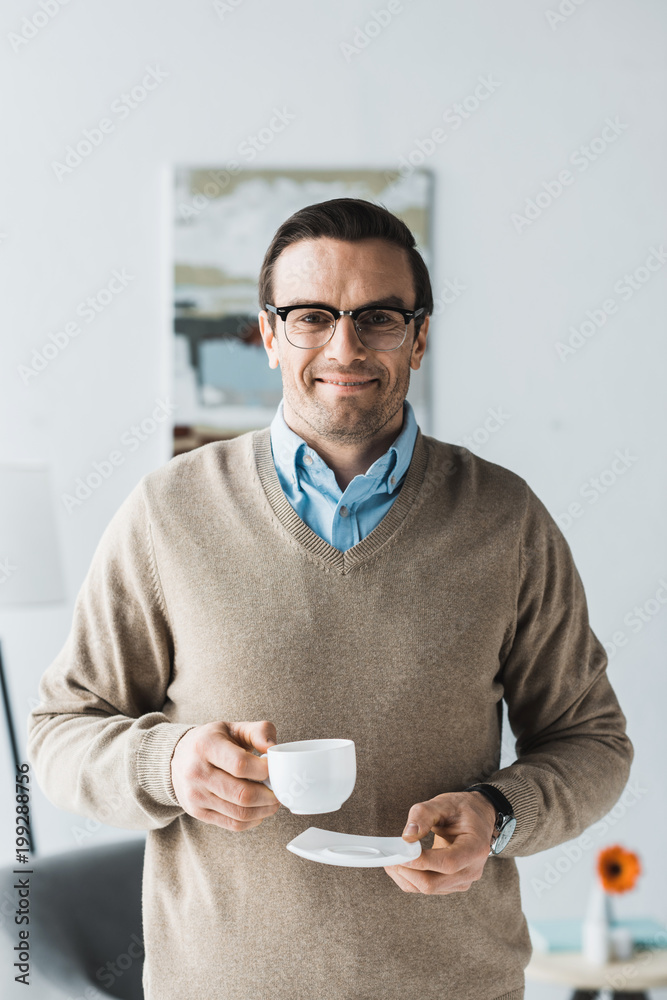 Happy man wearing glasses and holding cup of coffee Happy man wearing glasses and holding cup of coffee