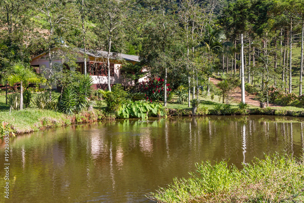 Farm house with lake, road and forest