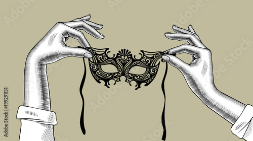 Woman's hands with a decorative carnival Venetian mask