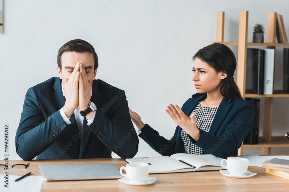 Colleagues in business suits arguing about project details in office Colleagues in business suits arguing about project details in office