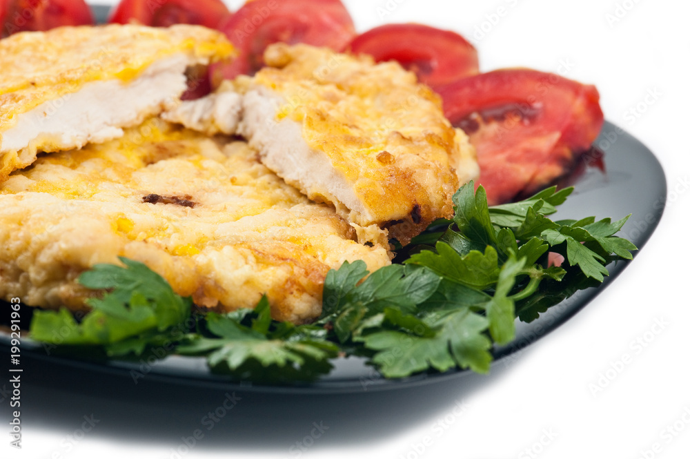 Chicken schnitzel with salad in the black plate on the white background. Chicken schnitzel with salad in the black plate on the white background.