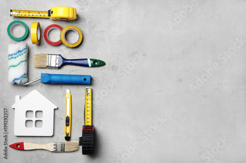 Set of decorator's tools on grey background, flat lay