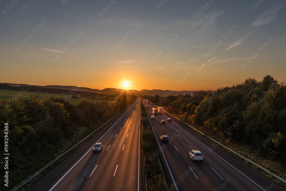 Fototapeta premium The road traffic on a motorway at sunset