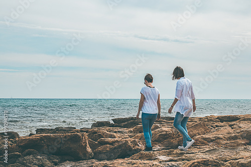 Two girls walking by the sea