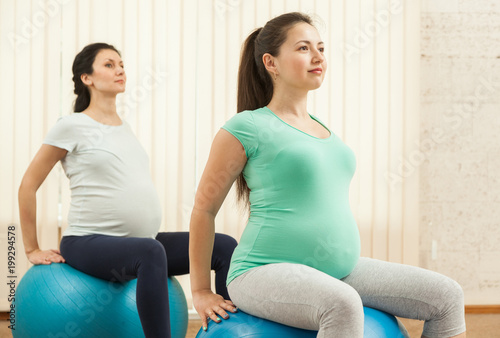 Beautiful pregnant women doing yoga on the balls