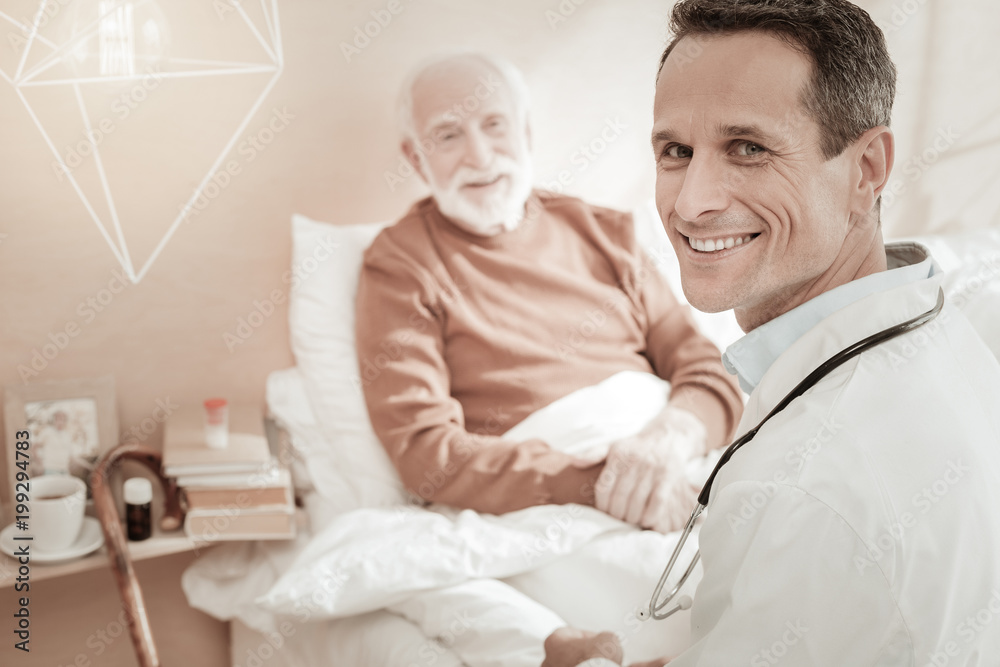 Best doctor. Satisfied qualified reliable doctor sitting near a patient smiling and turning head. Best doctor. Satisfied qualified reliable doctor sitting near a patient smiling and turning head.