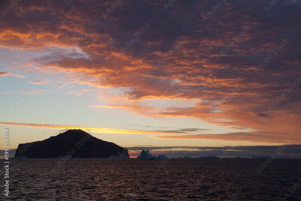 Paulet Island Antarctica, sunset with pink sky, island and iceberg silhouette