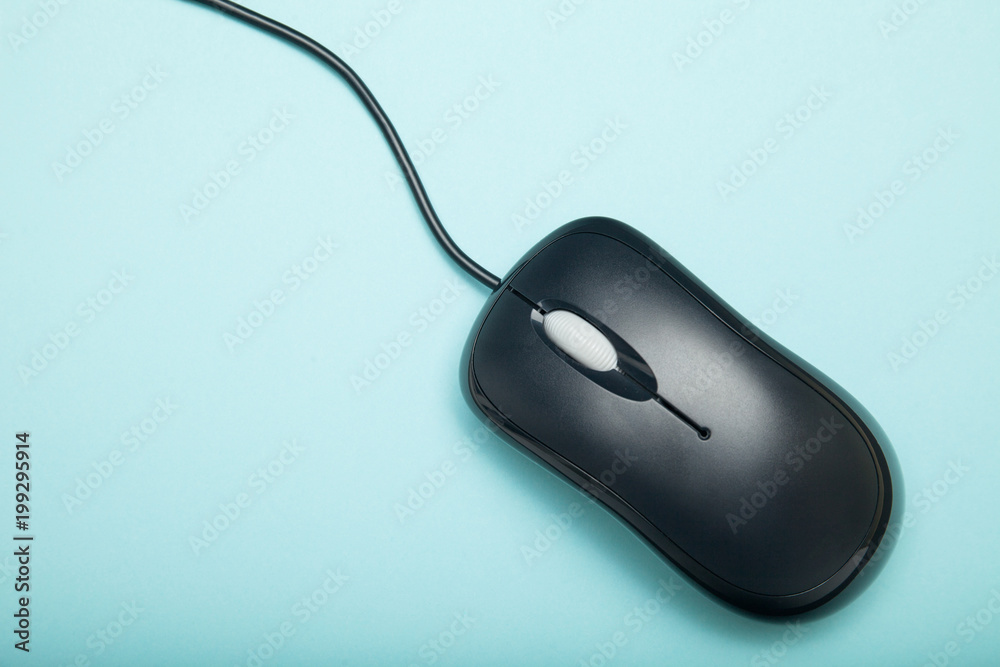 Black computer mouse close-up on a blue background. Black computer mouse close-up on a blue background.