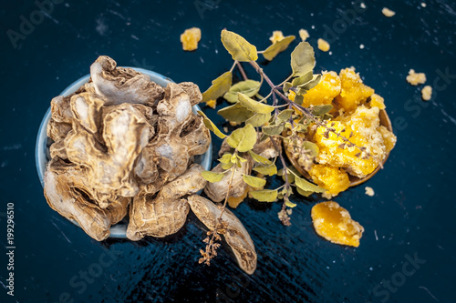 Beneficial tea of dried ginger or Zingiber officinale with benefits like help digestion, reduce nausea and help fight the flu and common cold in transparent cup with raw dried ginger. photo