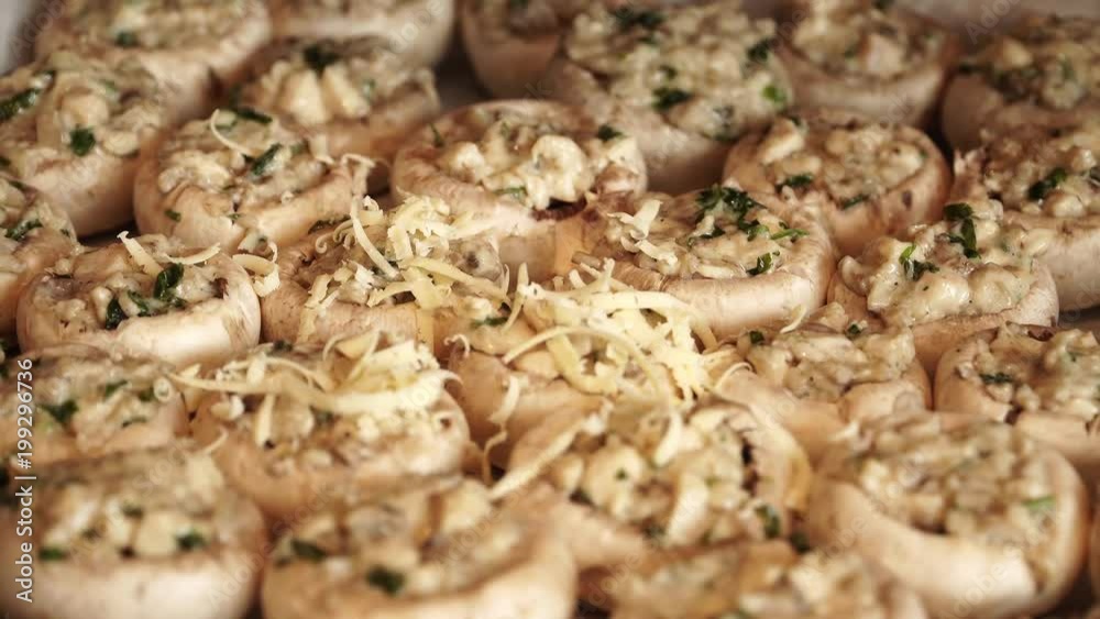 Mushrooms sprinkle grated cheese for baking on baking sheet Mushrooms sprinkle grated cheese for baking on baking sheet