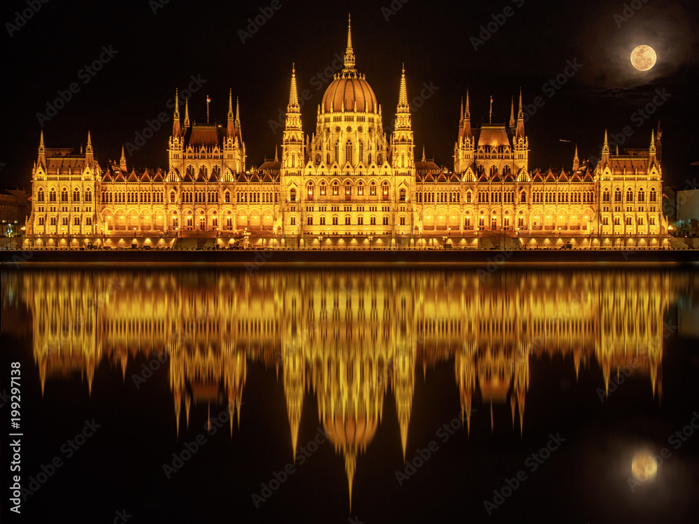 Fototapeta premium Hungarian Parliament Building (Budapest) at night reflected in water of Danube River and with full Moon above it