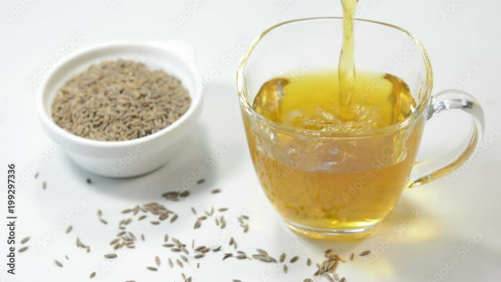 Pouring cumin tea in a cup. Cumin tea prepared by heating cumin seeds