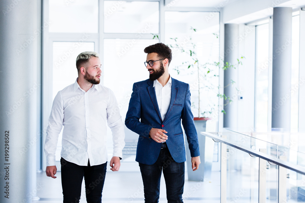Young Business Colleagues Discussing While Walking Young Business Colleagues Discussing While Walking