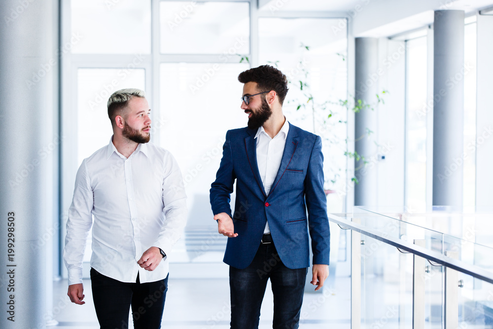 Young Business Colleagues Discussing While Walking Young Business Colleagues Discussing While Walking