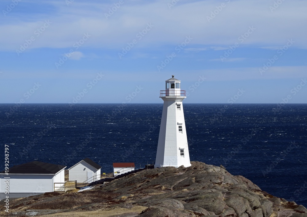 view towards the ocean at with the historic 19th century lighthouse in the foreground at Cape Spear National Historic site, Avalon region Newfoundland Canada