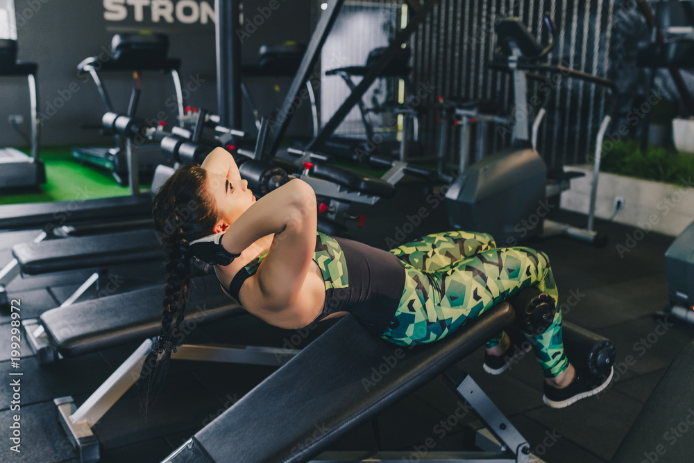 sport, fitness, bodybuilding, lifestyle and people concept - young girl doing sit-up abdominal exercises Bench Press in gym sport, fitness, bodybuilding, lifestyle and people concept - young girl doing sit-up abdominal exercises Bench Press in gym