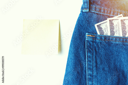 Large stack of money in the pocket of old vintage indigo stonewashed jeans. Modern trendy color photo