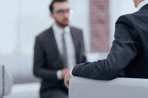 Image of young businessman communicating with his colleague