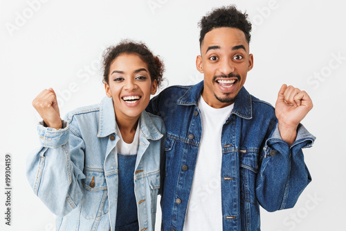 Cheerful african couple in denim shirts rejoices together