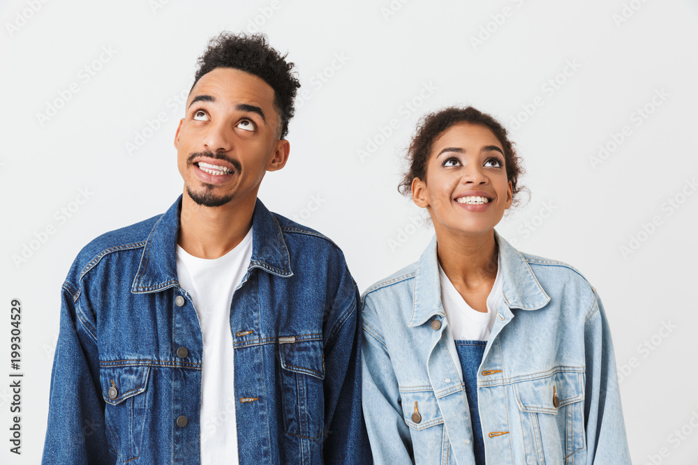 Happy couple in denim shirts posing together and looking up Happy couple in denim shirts posing together and looking up