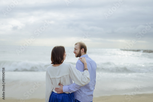 A loving couple, man and woman enjoying summer vacation on a tropical paradise beach with clear sea ocean water and scenic