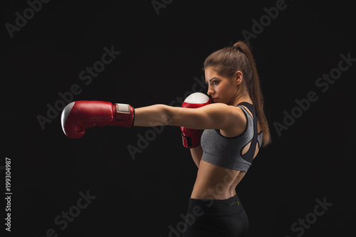 Side view of a gorgeous young woman with boxing gloves © Prostock-studio