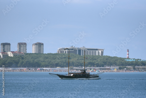 Pleasure boat on a background of city beach and blue sky © pridannikov