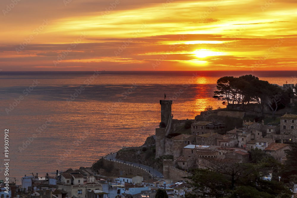 Sunrise in sea Tossa de Mar with the wall and the castle near the sea