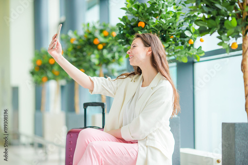 Beautiful woman in international airport. Tourist with smartphone indoor photo