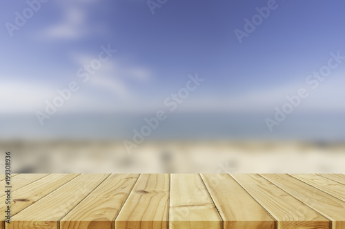 Wooden table in front of abstract blurred beach and sea background. For present your products. Summer Concept