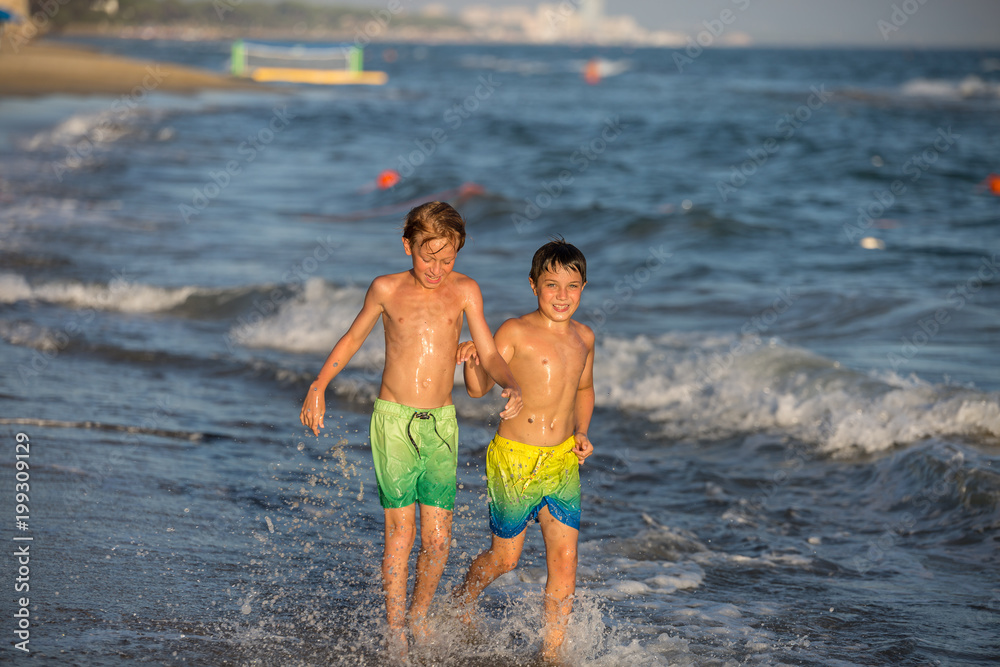 Happy Brothers Run on the Seashore: Summer Vacation Concept. Happy Brothers Run on the Seashore: Summer Vacation Concept.