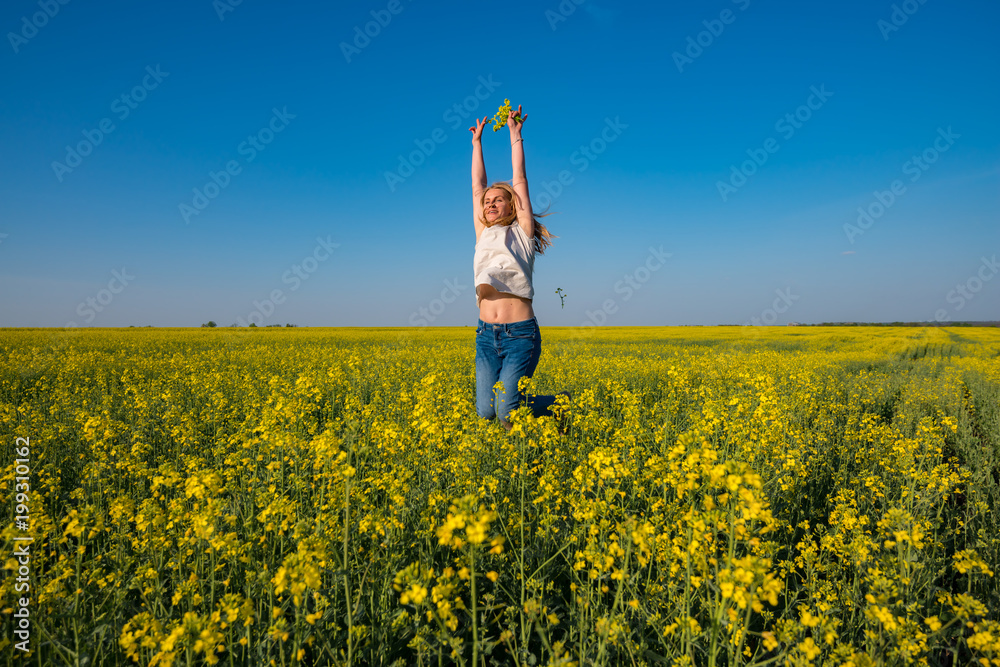 Fototapeta premium Young beautiful woman blonde, with open arms, jumps