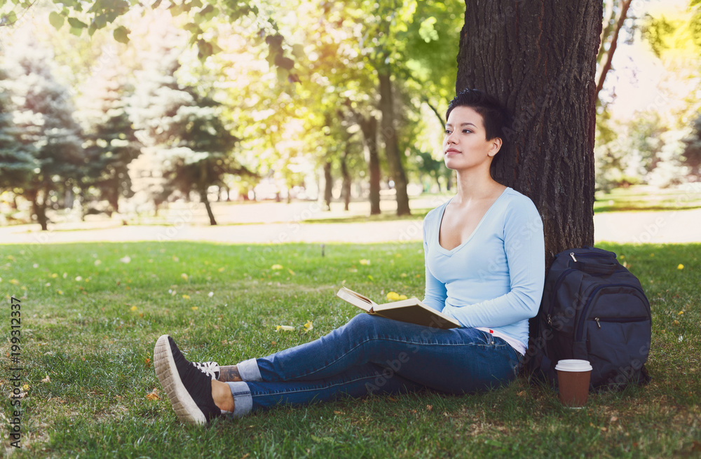 Attractive woman reading a book outdoors Attractive woman reading a book outdoors