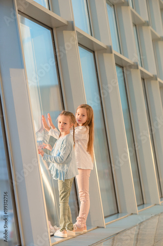 Little adorable girls in airport near big window
