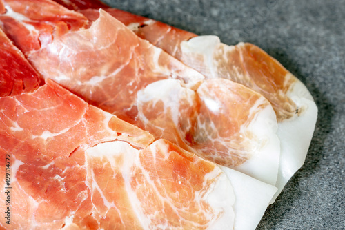 Italian prosciutto crudo or jamon. Raw ham. Isolated on vintage background