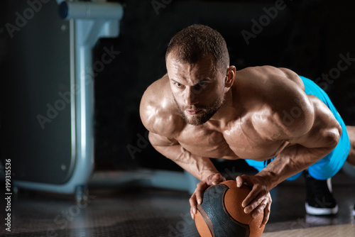 Muscular athletic man doing push up on cross fit ball