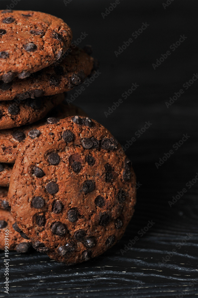 Fototapeta premium oatmeal cookies with chocolate on a dark wooden background