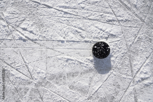 Photography hockey puck lies on the ice in the stadium
