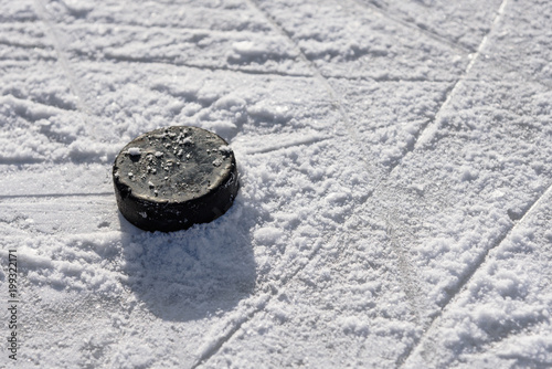 Photography hockey puck lies on the ice in the stadium