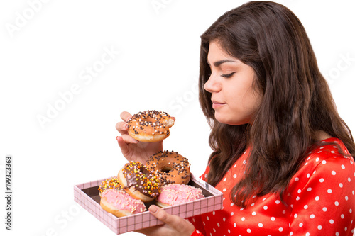An isolated shot of a beautiful caucasian woman eating donut