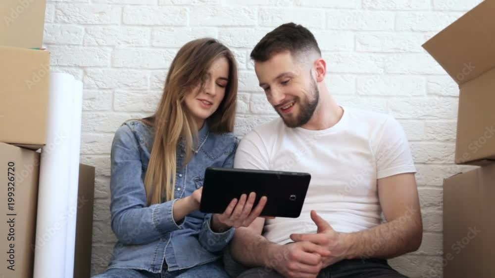 Happy couple planing new interiour. Using digital tablet. Slider shot. Happy couple planing new interiour. Using digital tablet. Slider shot.