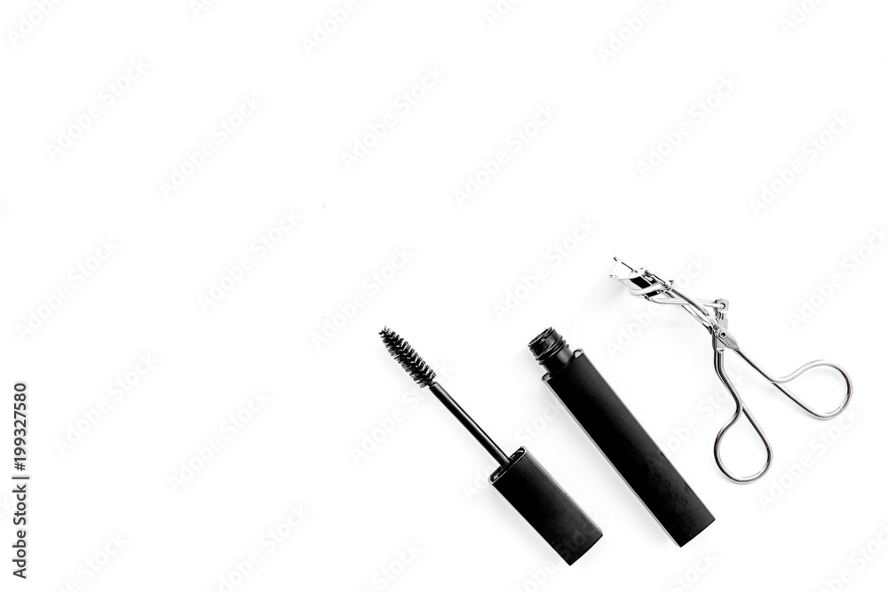 Basic products for eyelashes makeup. Mascara and eyelash curler on white background top view copy space Basic products for eyelashes makeup. Mascara and eyelash curler on white background top view copy space