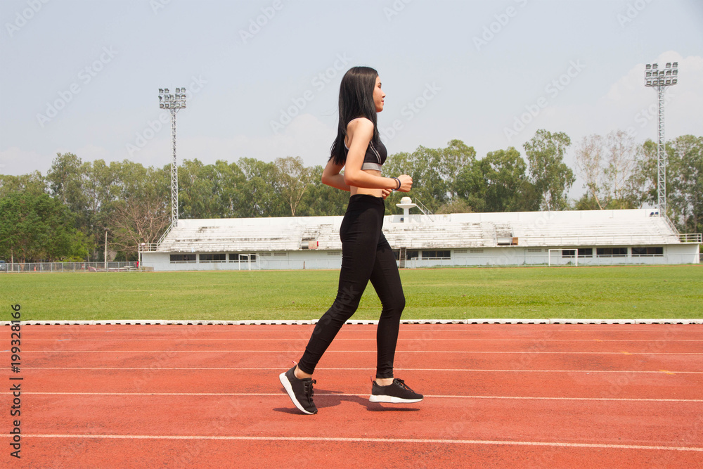 Obraz premium Asian lady running in track stadium