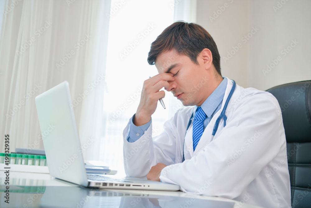 Doctor Concept. Doctors are making serious faces. The doctor is stressed about work. The doctor is feeling a headache at work. The doctor is feeling stressed in treating the patient. Doctor Concept. Doctors are making serious faces. The doctor is stressed about work. The doctor is feeling a headache at work. The doctor is feeling stressed in treating the patient.